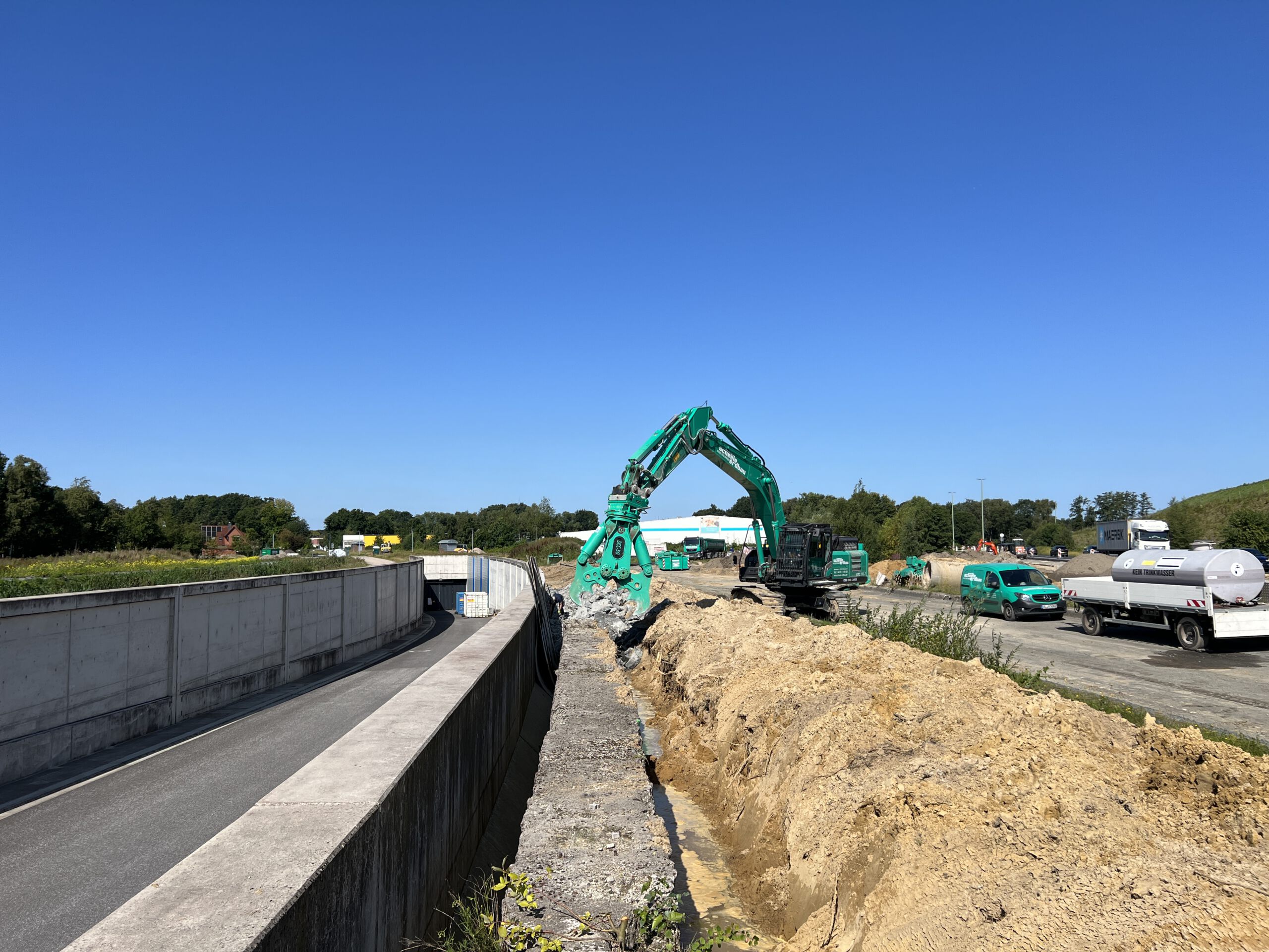 Bautätigkeiten mit einem grünem Bagger am Hafentunnel in Bremerhaven